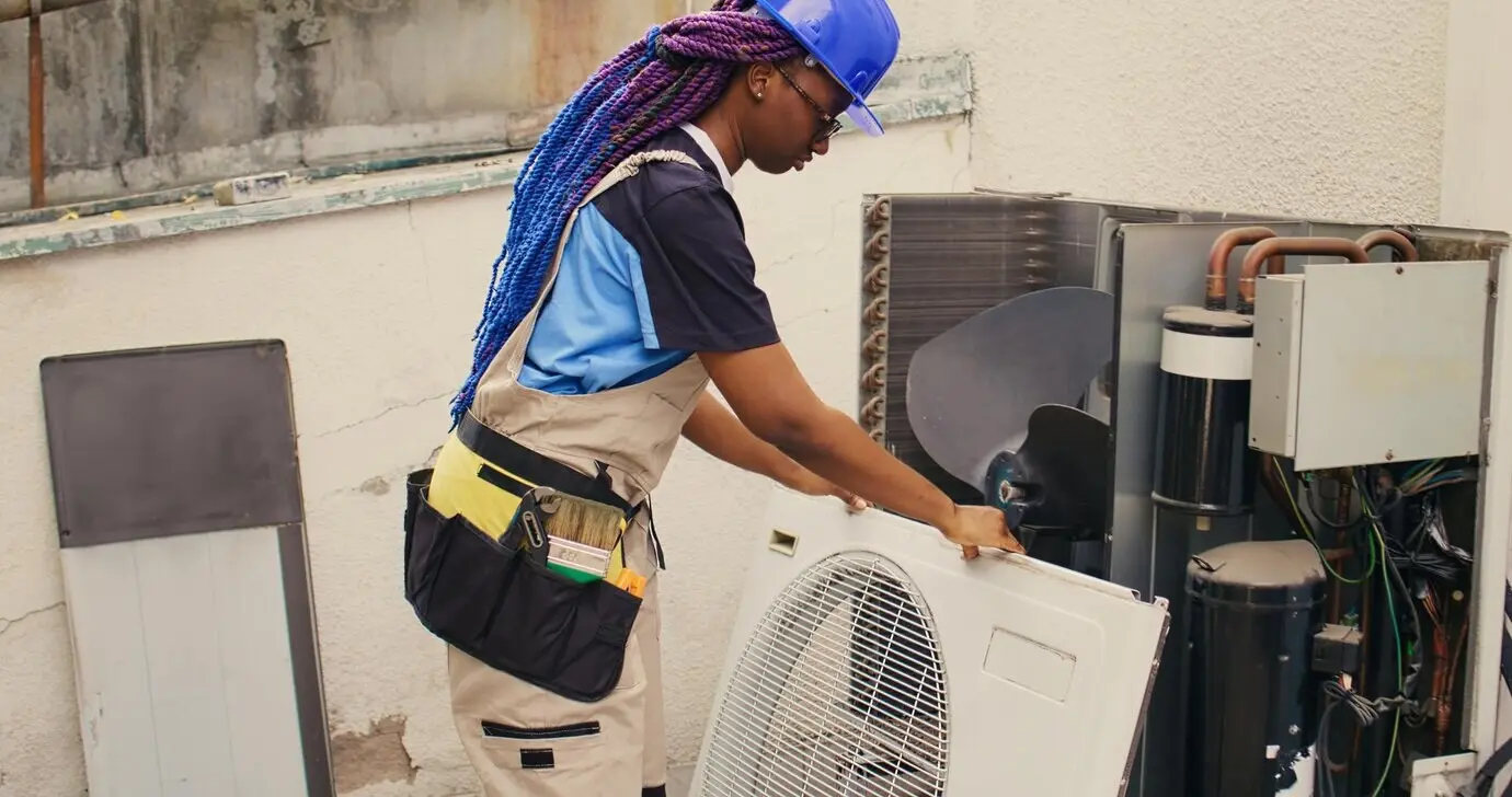 A repairman working on an air conditioner.